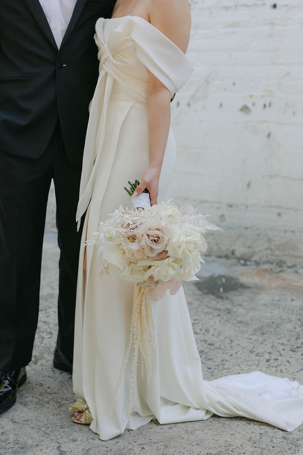 modern white wedding bouquet and bow wedding dress